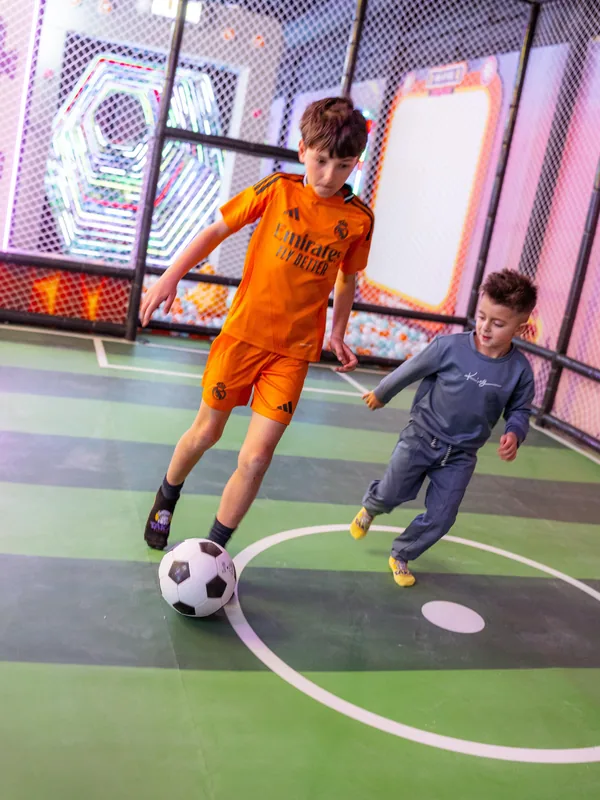 Niños jugando al fútbol en la pista de TAKA